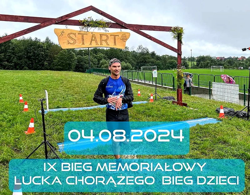 Biegacz przed startem biegu, baner z nazwą i datą.
