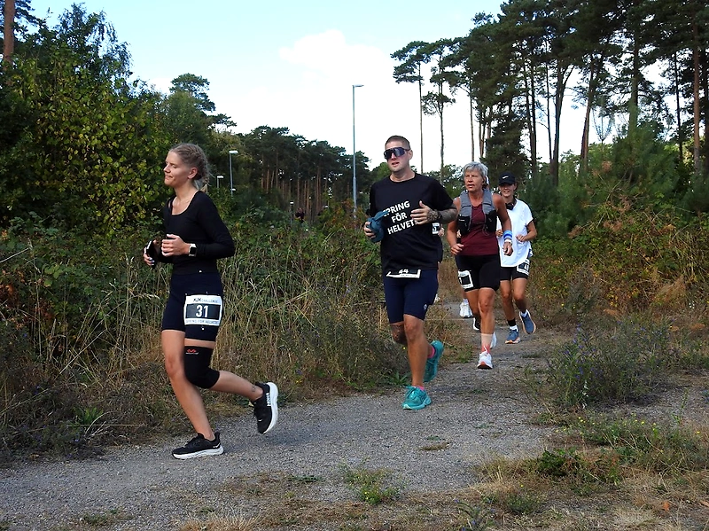Deltagare springer på en grusväg under ett Backyard Ultra lopp i Sölvesborg.