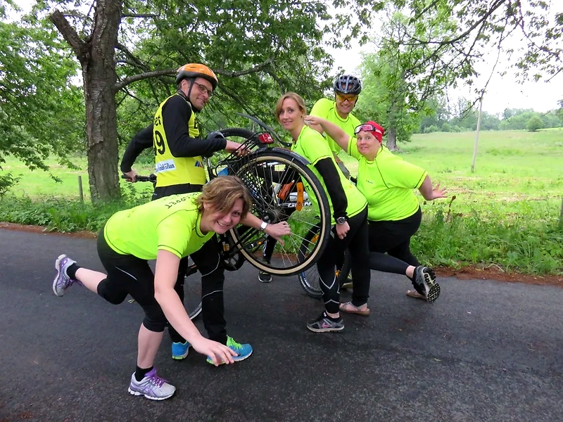 A group of cyclists posing with their bikes, probably before or after the race.