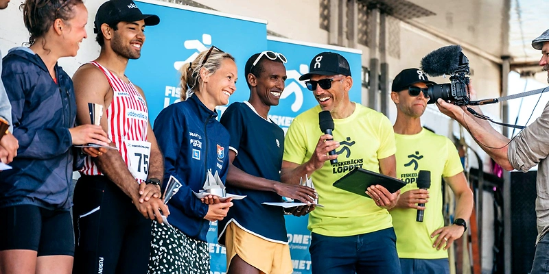 Löpare på podiet med Fiskebäcksloppets logotyp och priser.