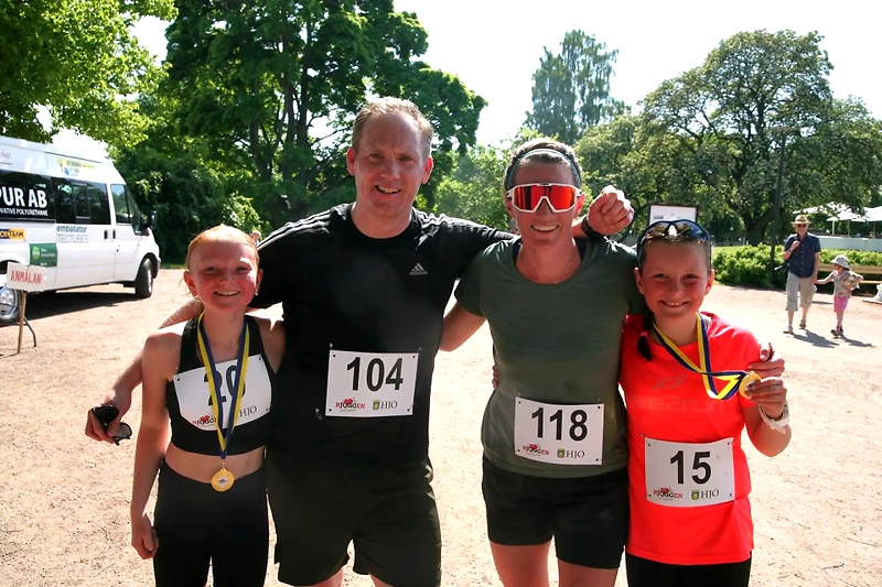 Familj efter löptävling med medaljer och nummerlappar.