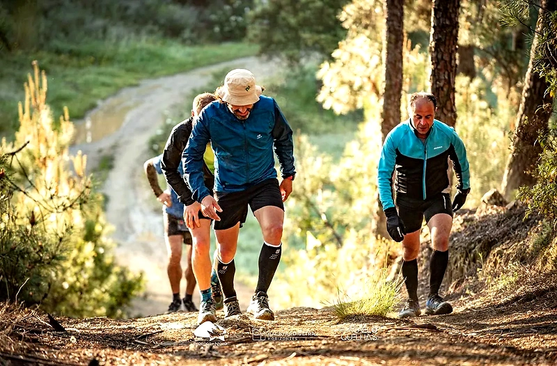 Löpare på stig i skogen, klädda i sportkläder.