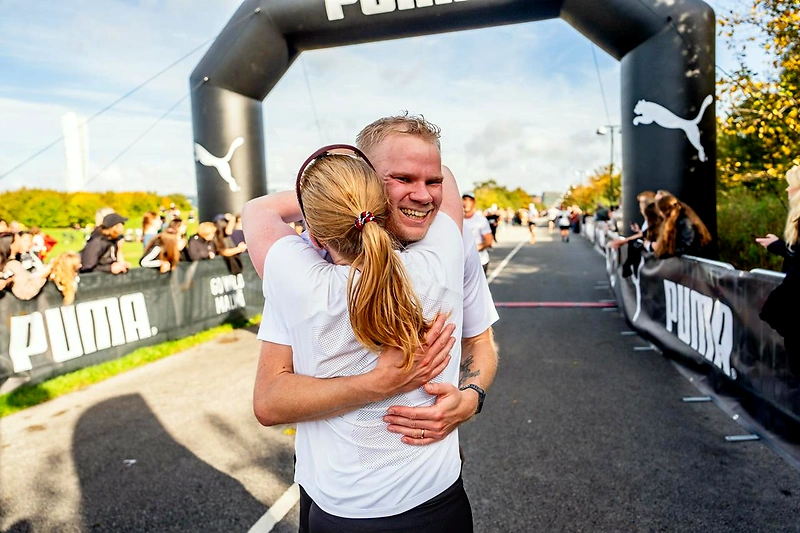 Två löpare kramar varandra vid mållinjen under Malmö Marathon.