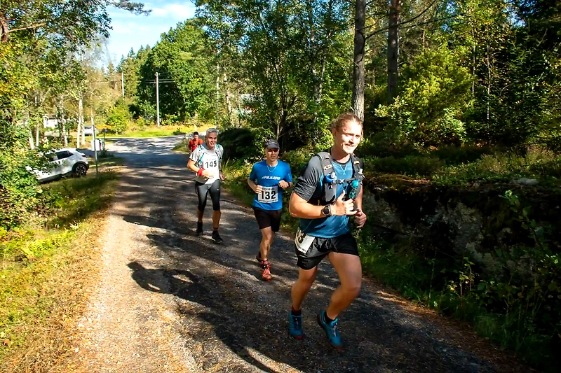 Löpare på terrängloppsstig i skogen.