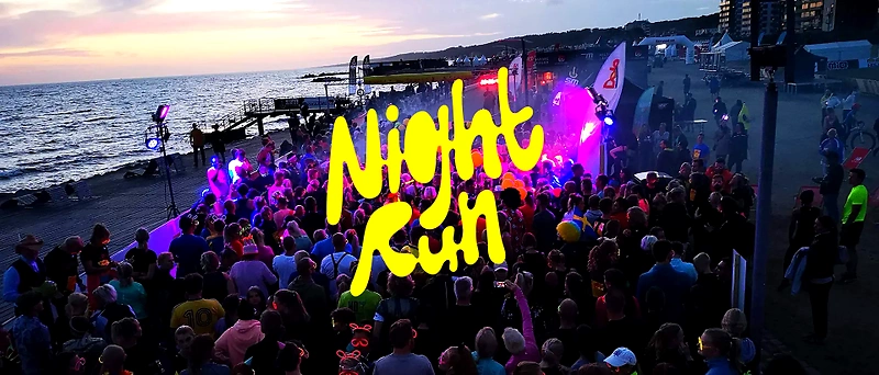 Night running party with a large crowd, lights, and