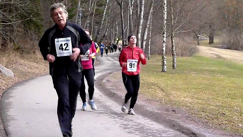Löpare i Två Sjöar Runt. Löparna bär nummerlappar och springer på en väg.