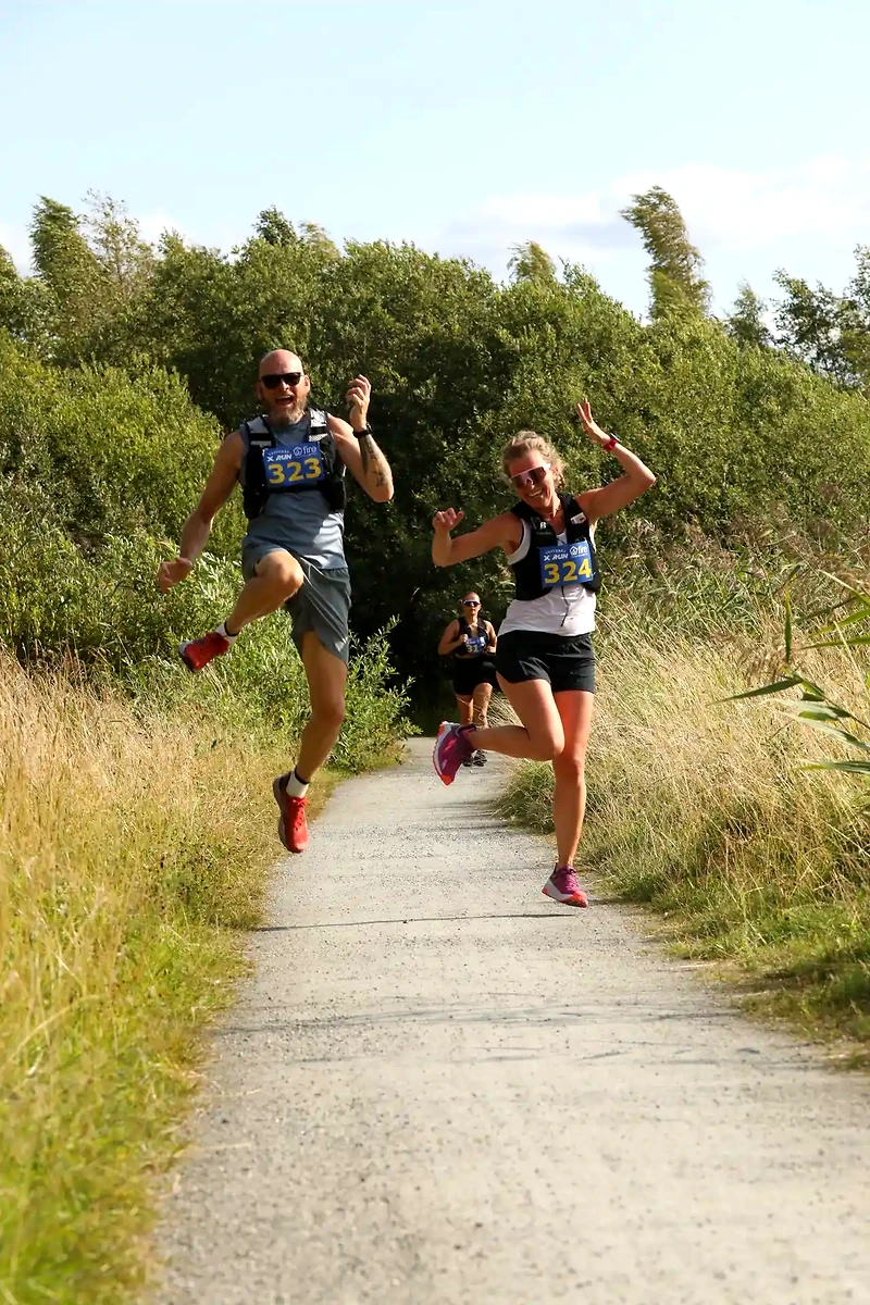 Löpare glada på stig under Västerås Trail Run.