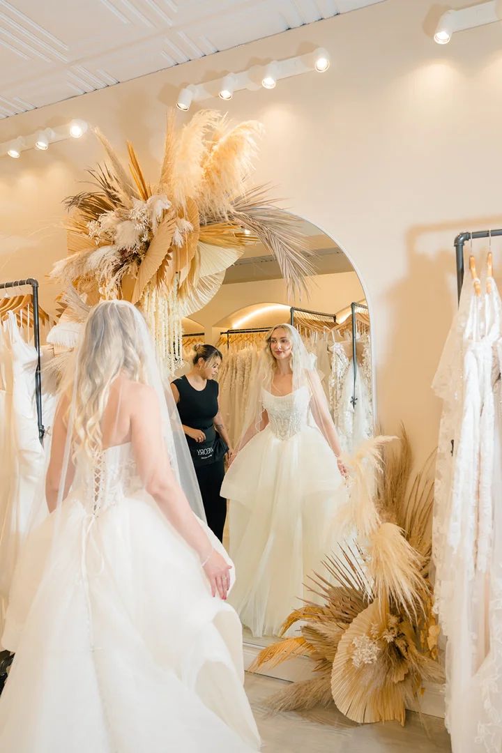 Personal stylist assisting a bride with a designer wedding dress fitting