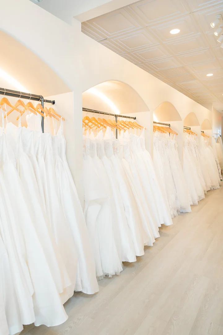 boutique showroom displaying designer gowns on racks