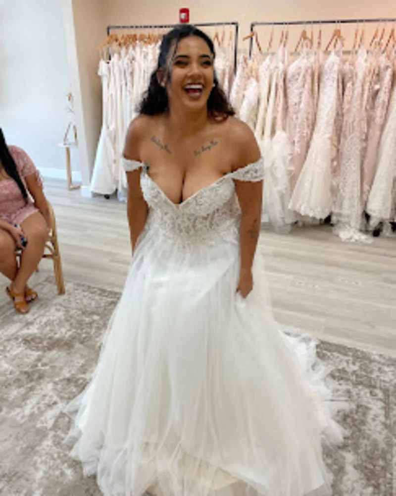 A bride trying on a luxurious ball gown wedding dress during an intimate boutique appointment