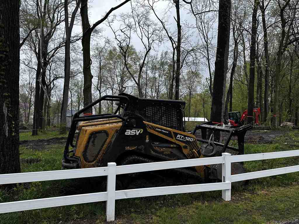 Forestry mulcher converting dense brush and small trees into protective mulch layer on cleared land - clearing and grading companies near me Forestry mulcher converting dense brush and small trees into protective mulch layer on cleared land - clearing and grading companies near me