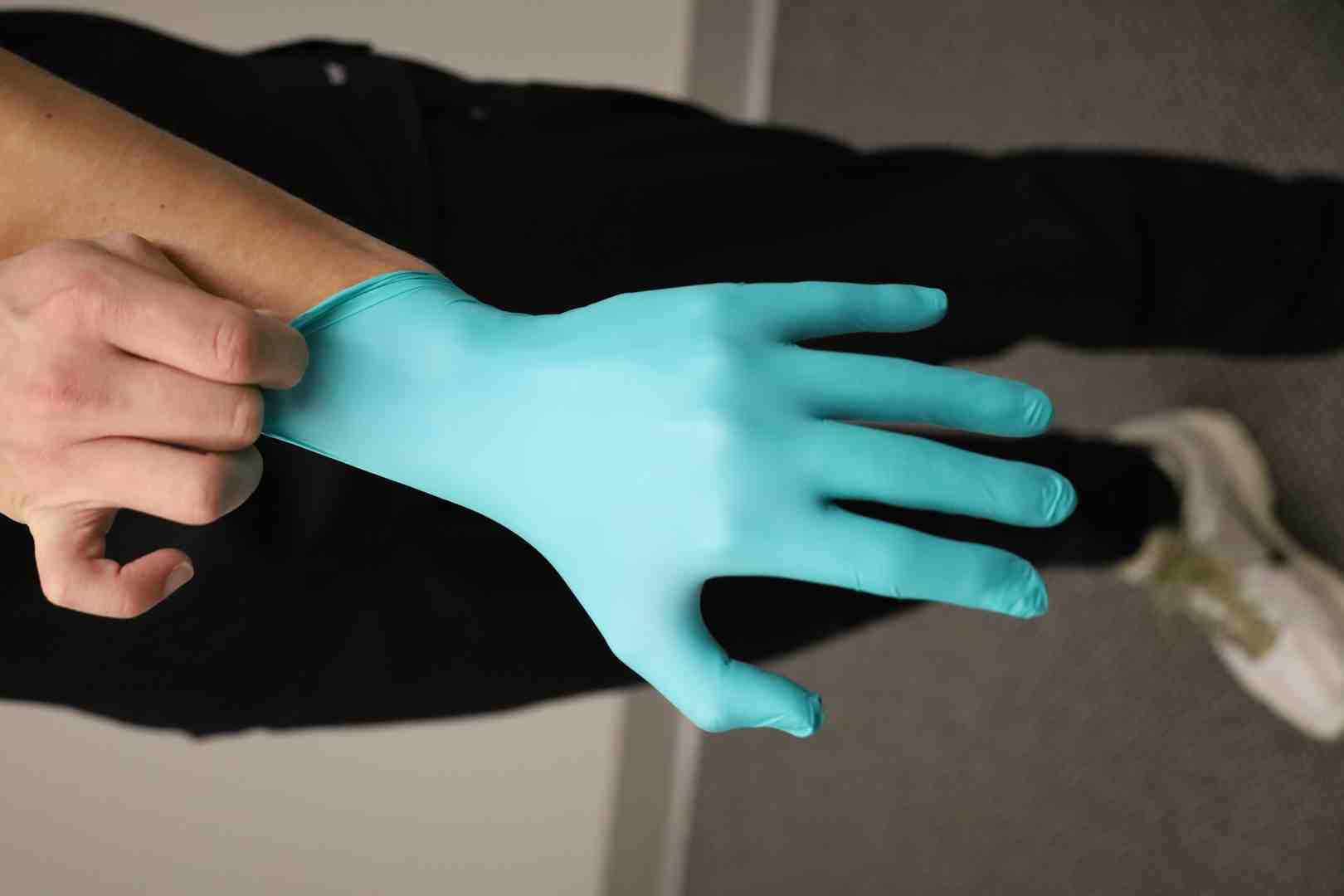 A dental professional correctly donning nitrile gloves - dental patient protection