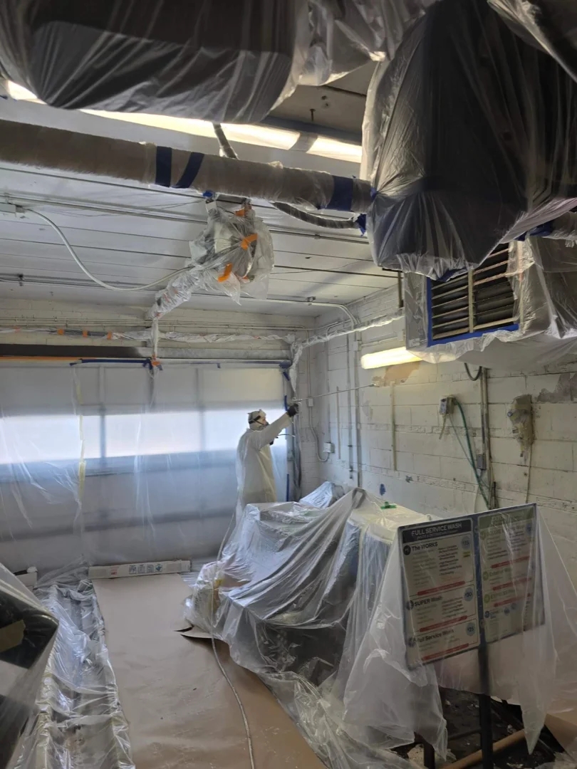 A professional technician carefully adjusting the fluid control and air pressure dials on a spray gun nozzle A professional technician carefully adjusting the fluid control and air pressure dials on a spray gun nozzle