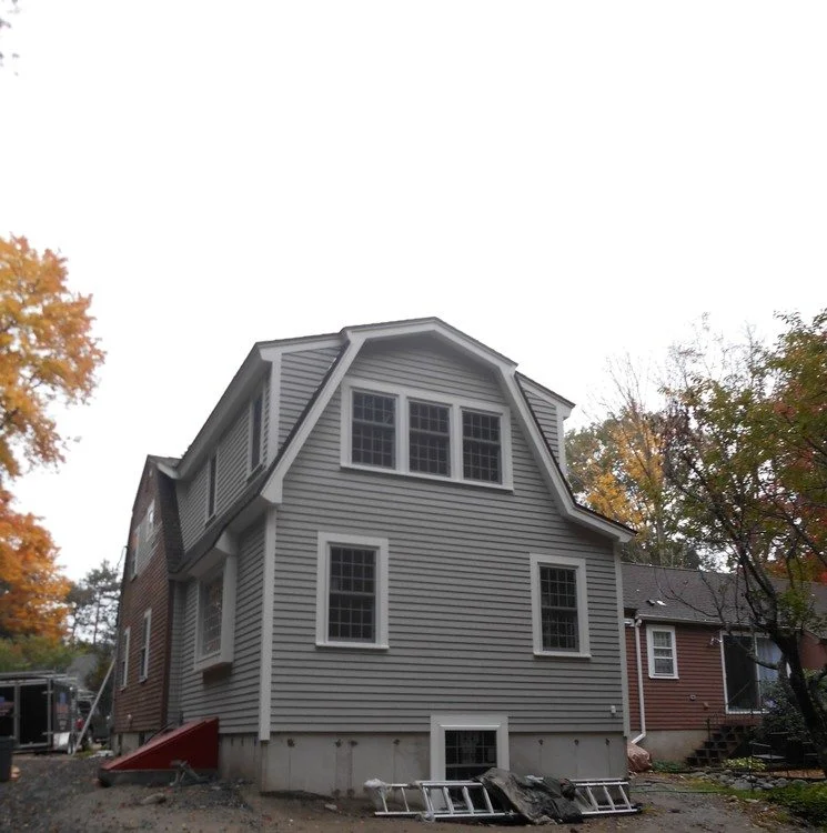 Completed ranch-to-two-story transformation showing modern colonial style