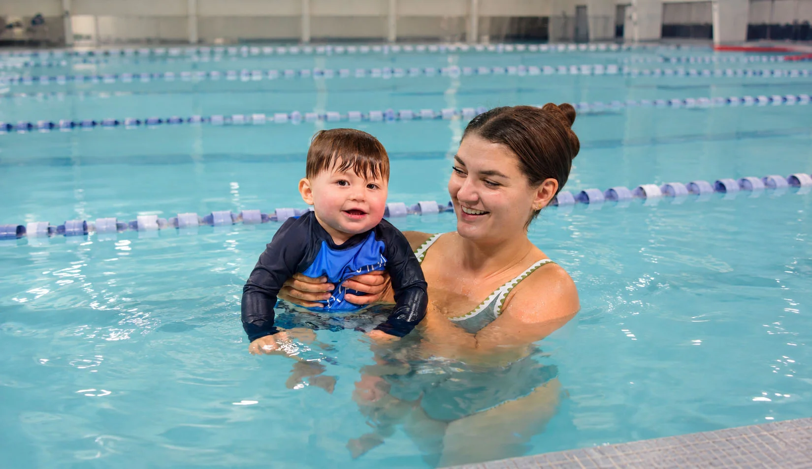 parent holding baby in warm pool parent holding baby in warm pool