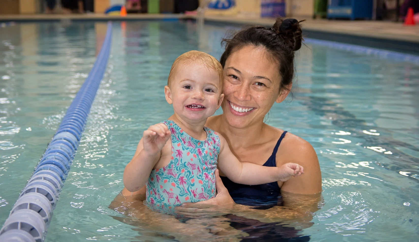 parent holding a baby in a warm pool parent holding a baby in a warm pool