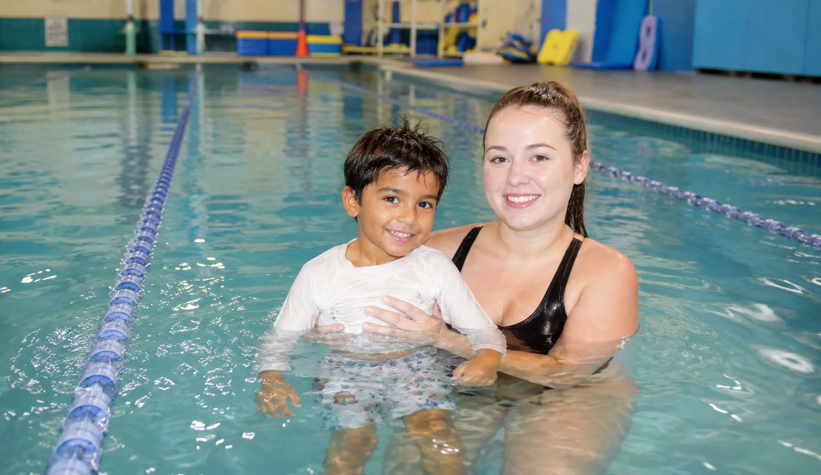 Small group swim class practicing kicking skills with an instructor Small group swim class practicing kicking skills with an instructor