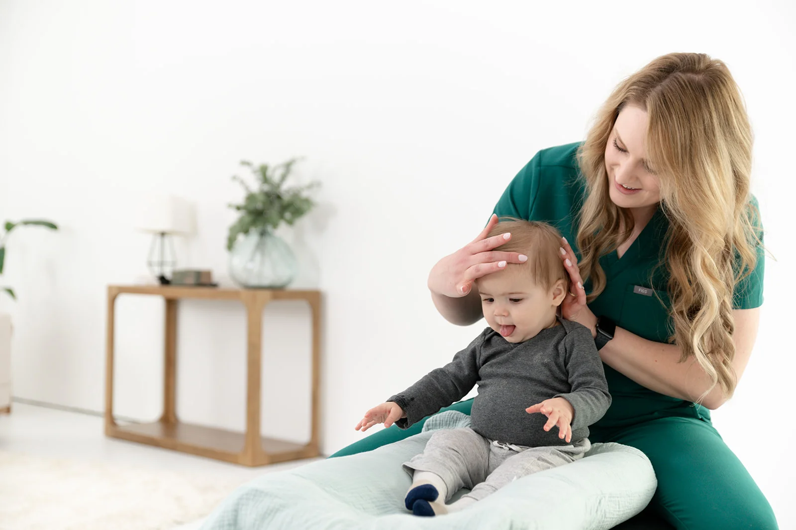 Chiropractor performing a gentle pediatric assessment on an infant in a calm setting - Signs Your Baby May Have Tension Chiropractor performing a gentle pediatric assessment on an infant in a calm setting - Signs Your Baby May Have Tension