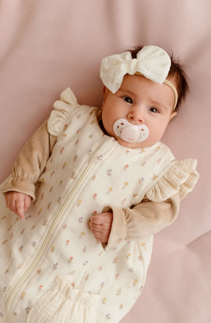 infant resting safely on back in a soft neutral nursery crib