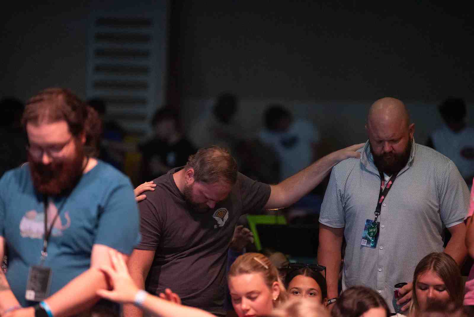 A mission team gathered in a circle for prayer before starting a day's work. - short term christian mission trips