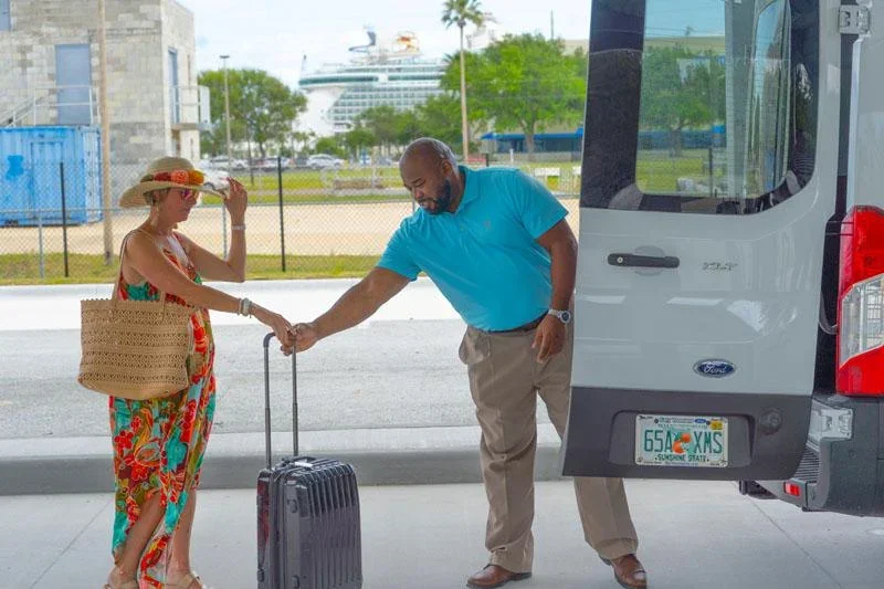 Luggage being loaded into the back of a cruise terminal parking shuttle
