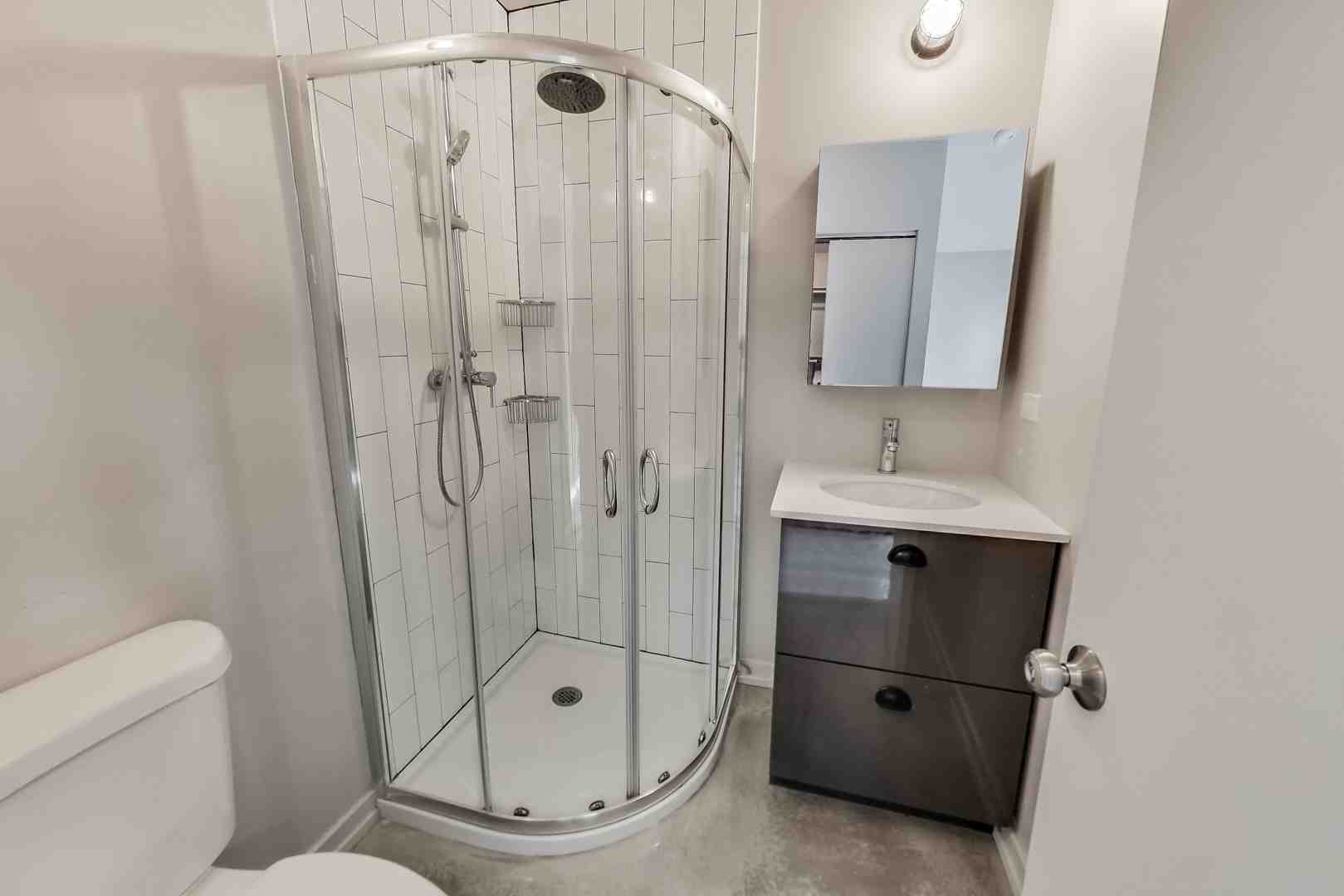 Spacious walk-in shower design featuring modern glass enclosure