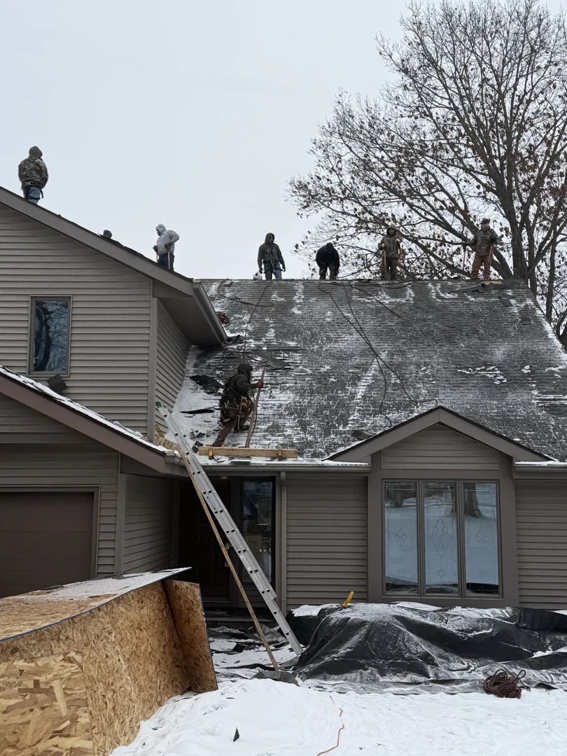 Roofers tearing off old asphalt shingle layers Roofers tearing off old asphalt shingle layers