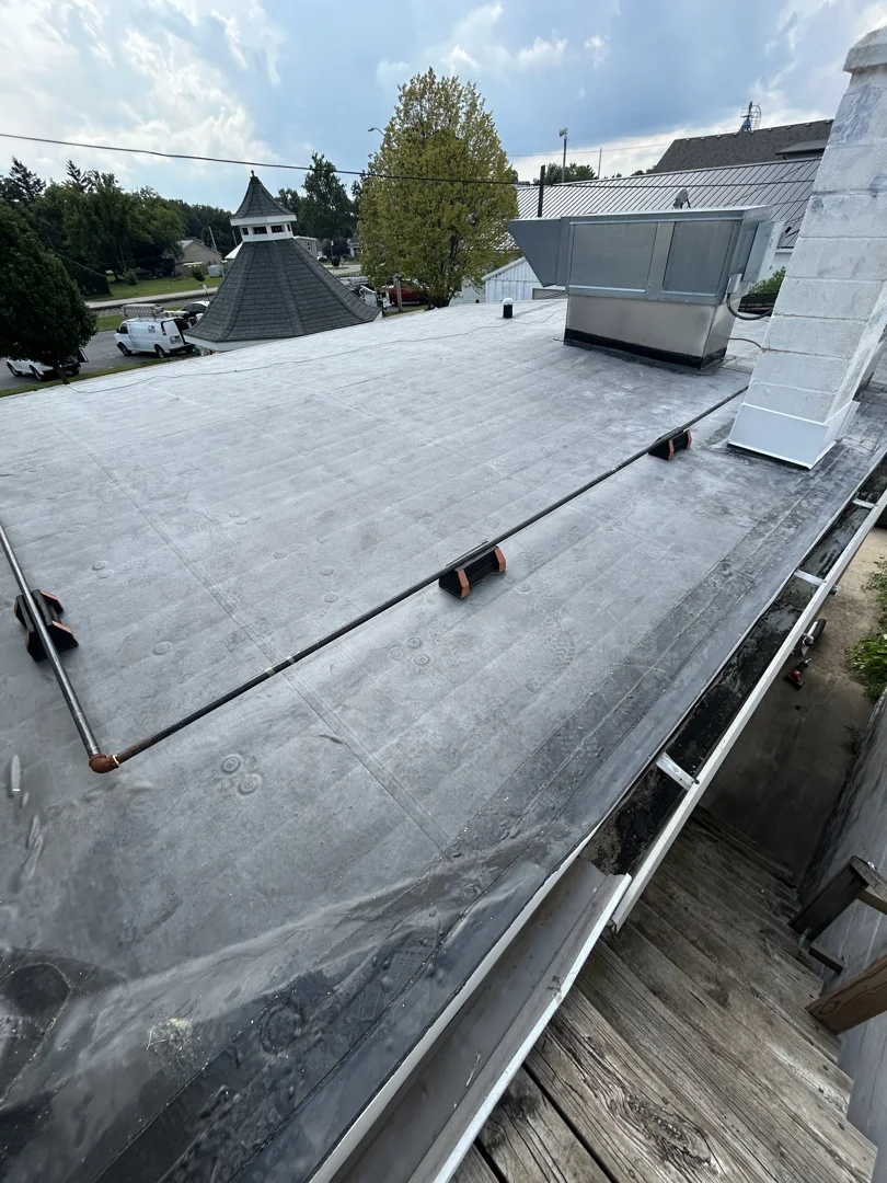 Roofing professional inspecting a TPO membrane for micro-fractures after a storm Roofing professional inspecting a TPO membrane for micro-fractures after a storm