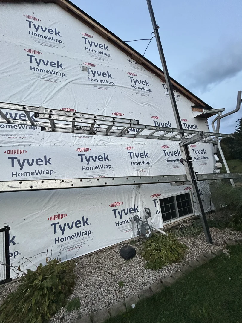 Inspecting moisture damage and rotted wall sheathing on home exterior Inspecting moisture damage and rotted wall sheathing on home exterior