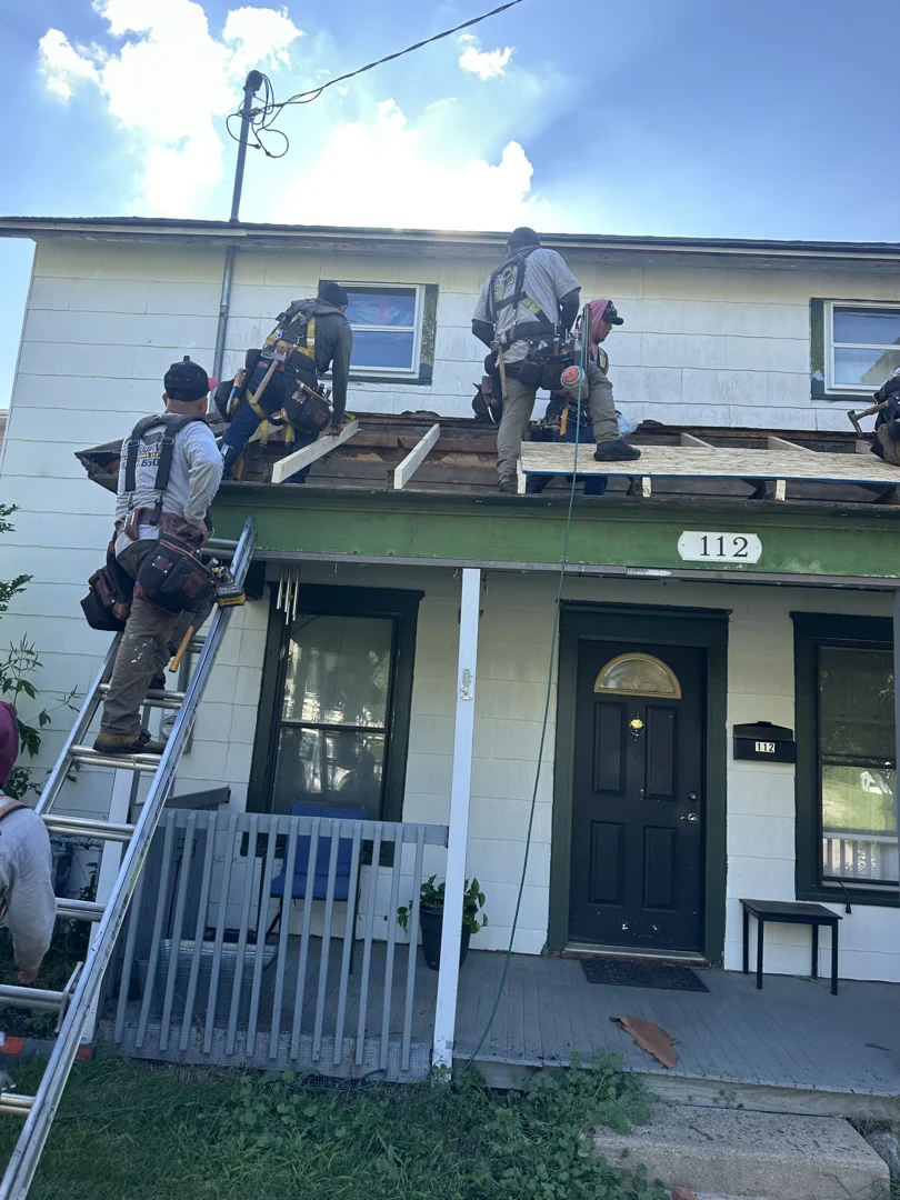Adjuster and local roofing contractor inspecting storm damage on a residential roof Adjuster and local roofing contractor inspecting storm damage on a residential roof