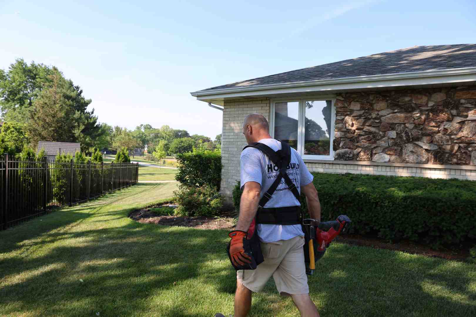 Contractor organizing tools like a level, drill, and shims - porch door installation