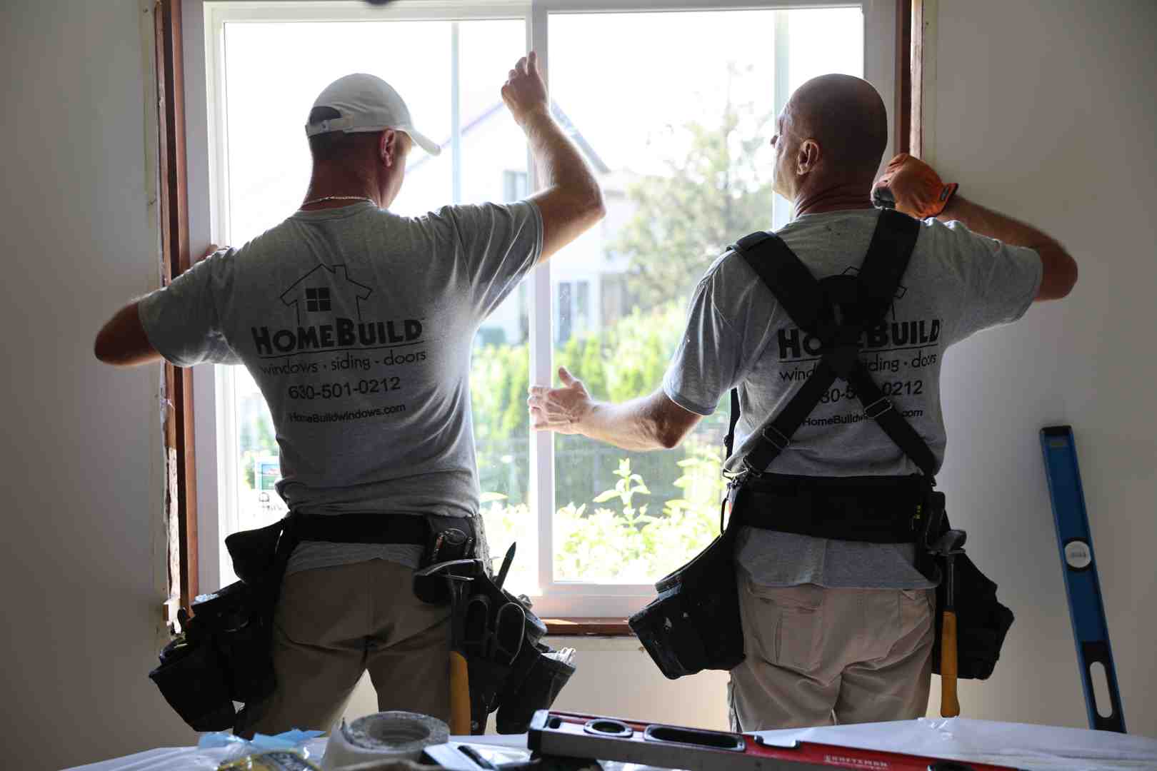 HomeBuild professional window installers carefully sealing a new Low-E window at a suburban Chicago home - Low-E windows
