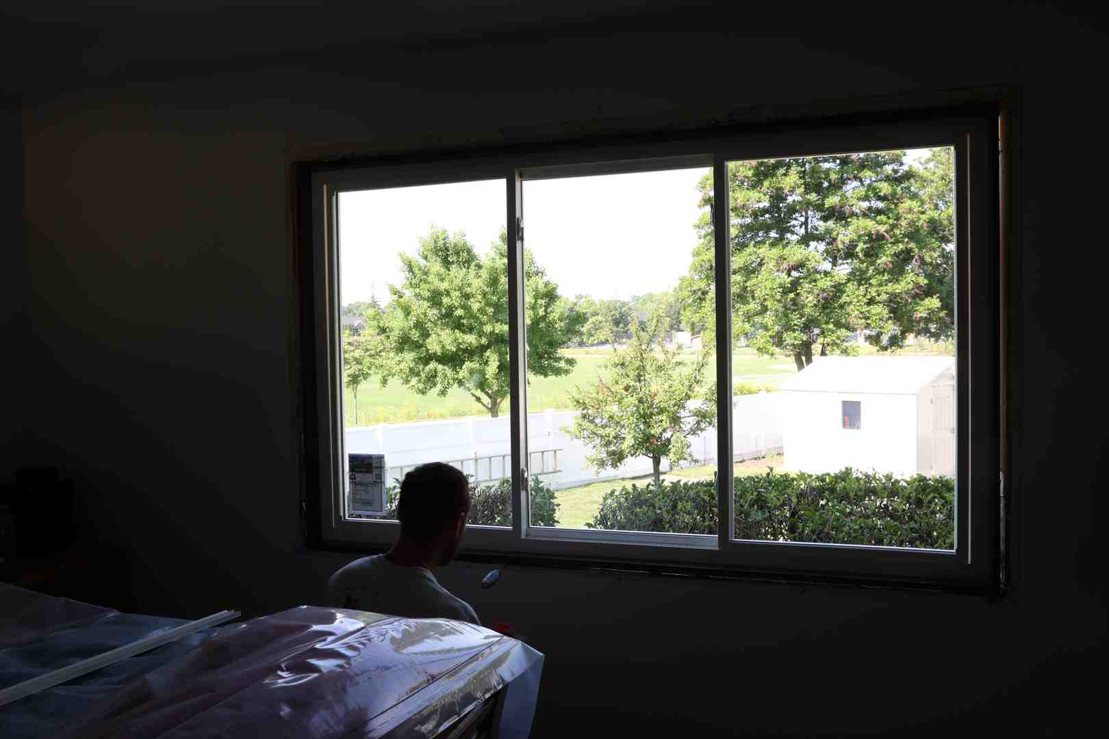 Homeowner evaluating newly installed composite replacement windows