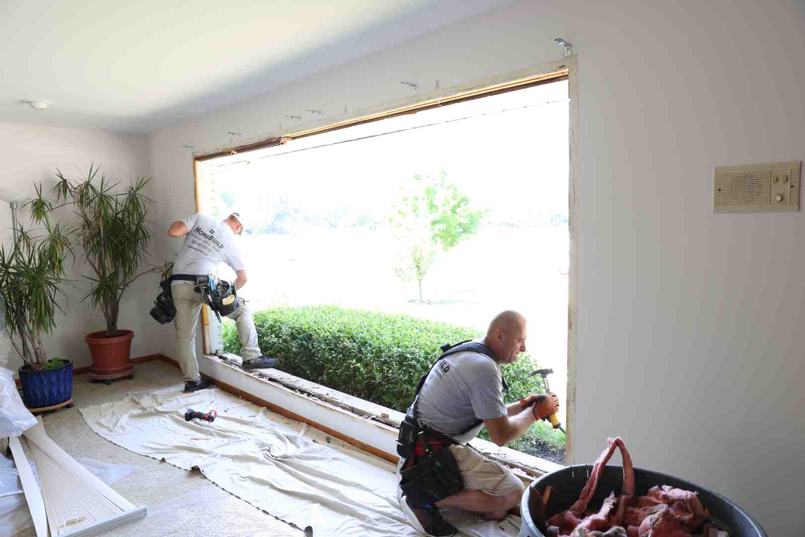 person carefully removing an old window frame - how to install window casement