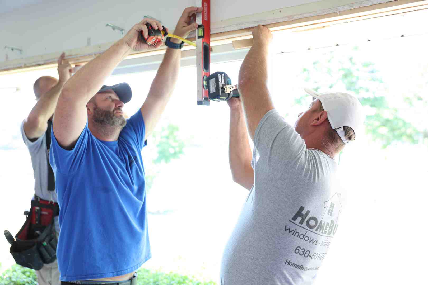 Professional window installer carefully leveling a new window frame during installation - cheap window installers near me