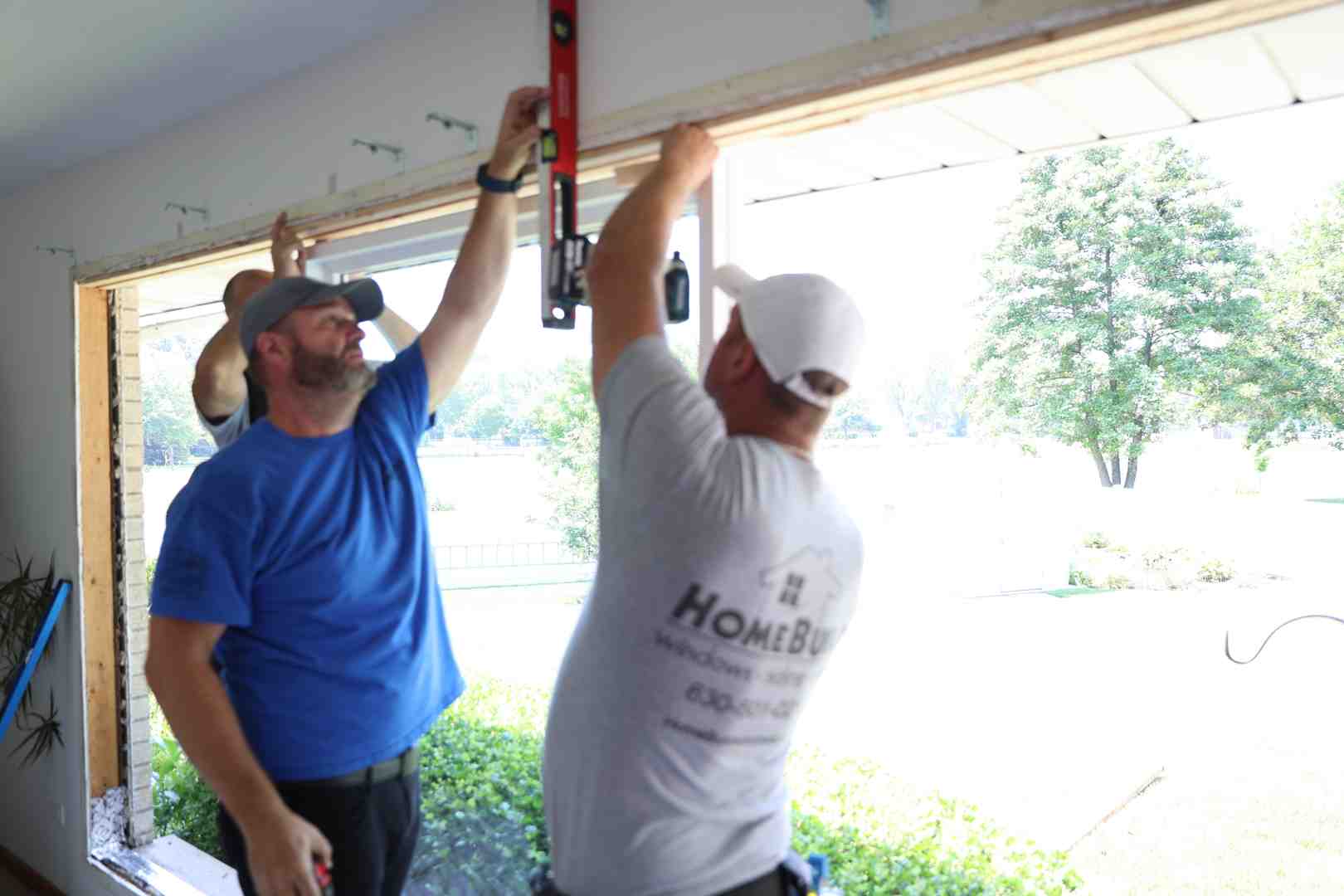 A professional installer carefully fitting a new window into an existing frame, ensuring a level and plumb fit before securing and sealing it. - best window installers near me reviews