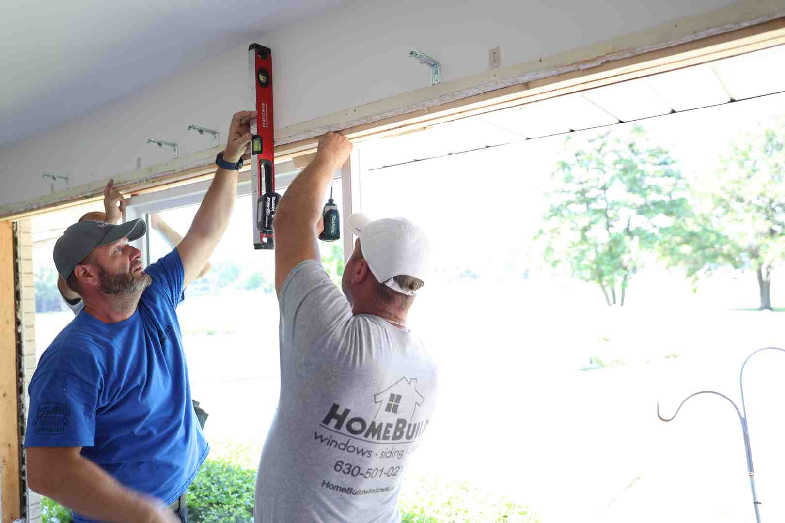 Expert window installer taking precision measurements of a vinyl window frame - affordable window replacement Elk Grove