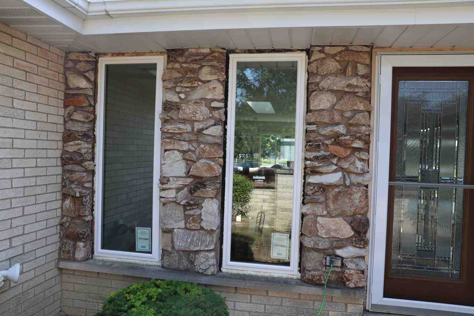 A beautiful home exterior featuring new fiberglass windows, fiber cement siding, and a modern entry door