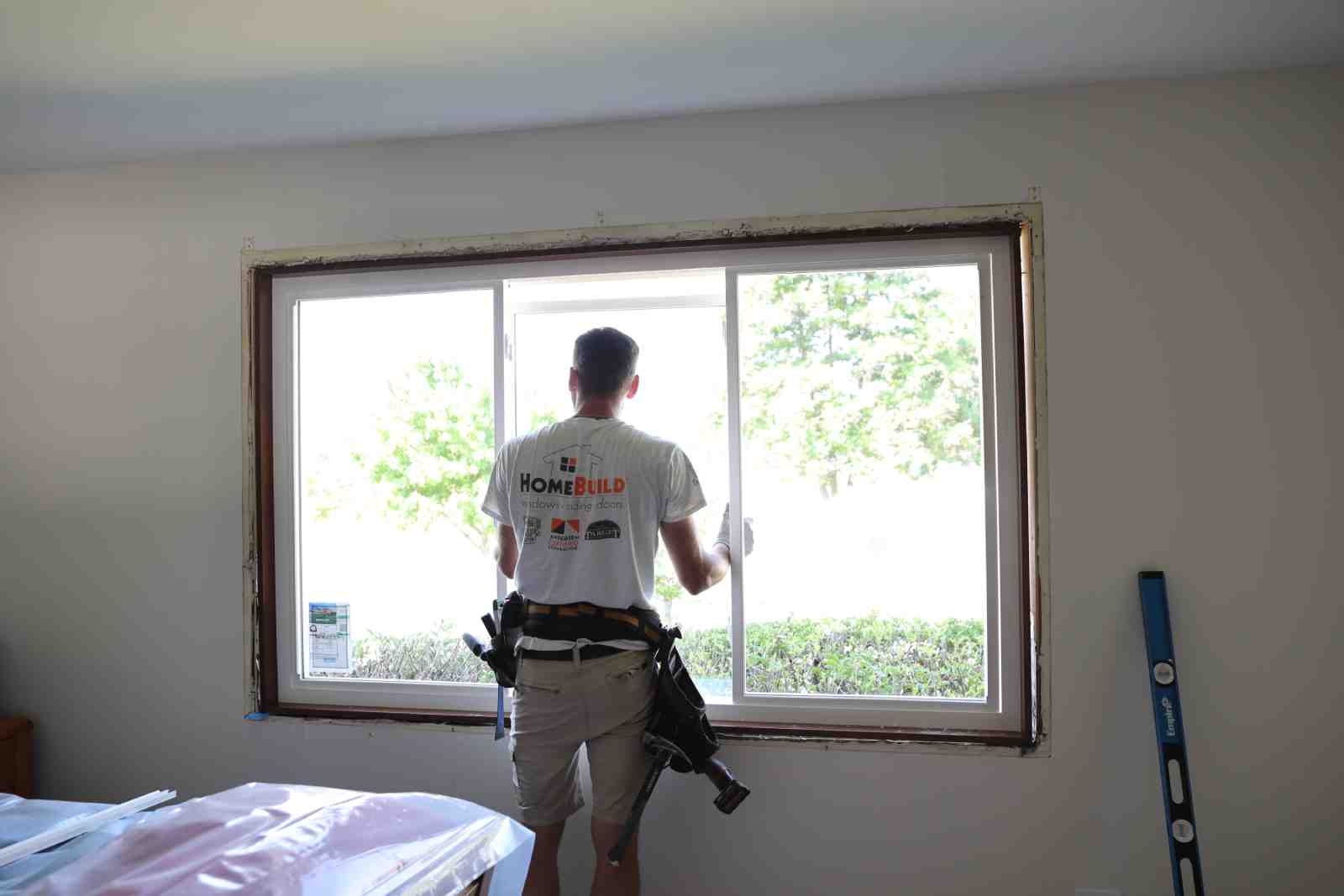 a certified installer carefully fitting a new window into a frame - new windows Buffalo Grove