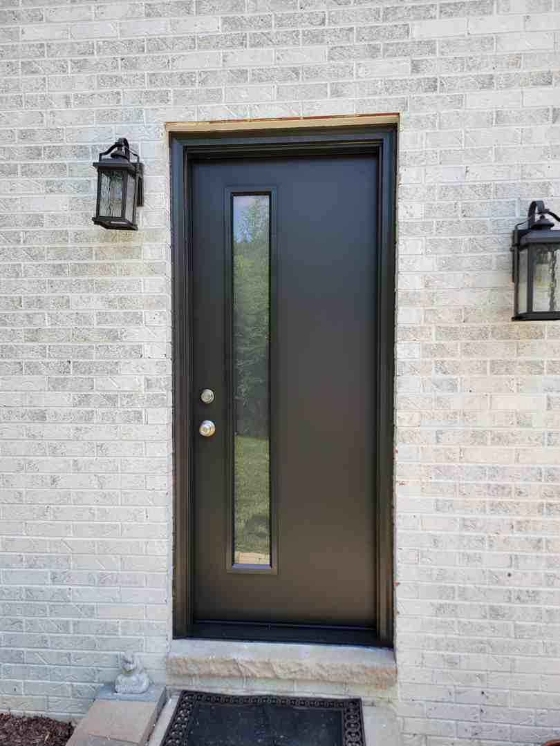 Decorated front porch with black entry door and white sidelights