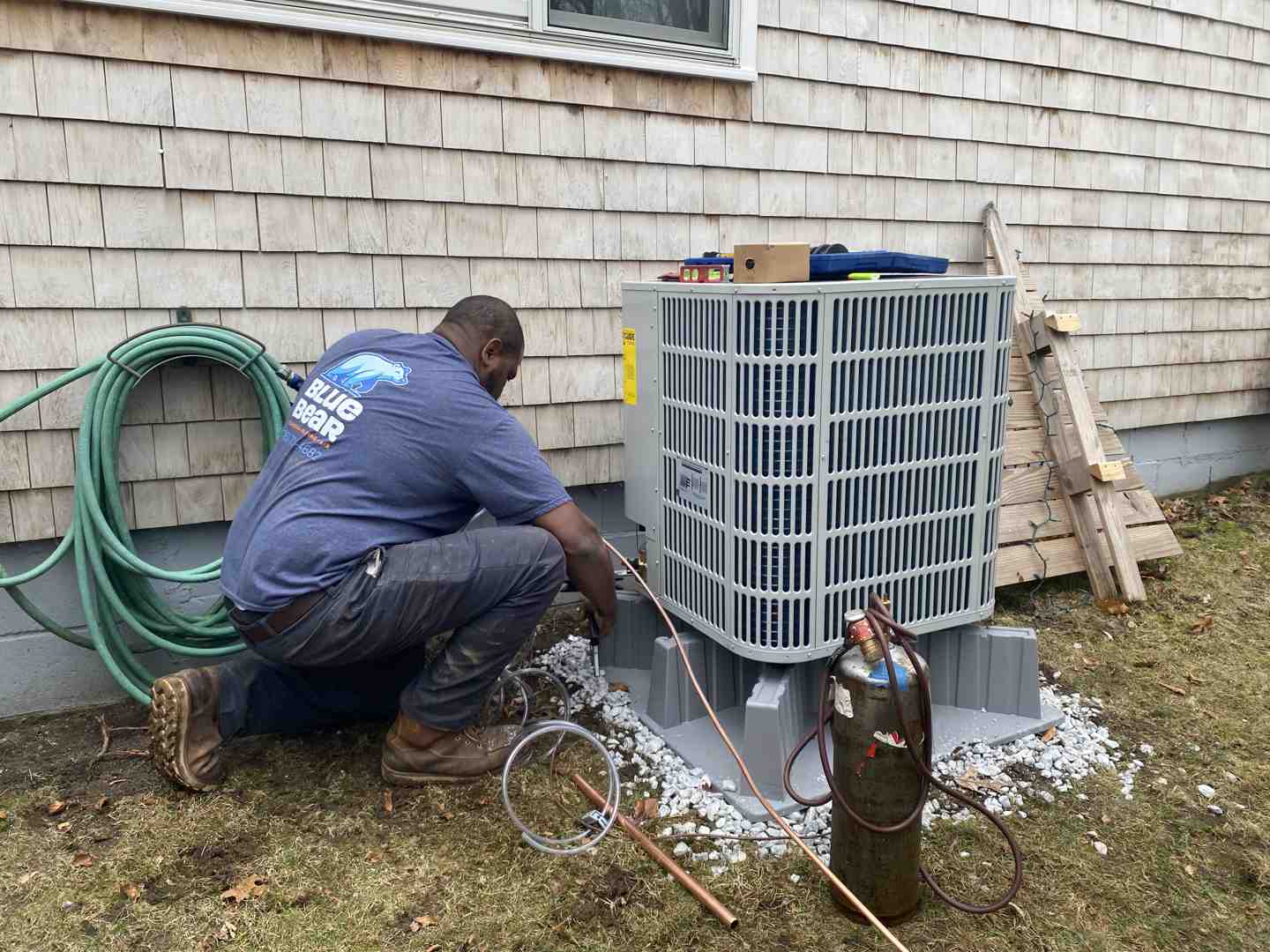 technician inspecting outdoor condenser unit - spring ac and hvac maintenance for the south shore technician inspecting outdoor condenser unit - spring ac and hvac maintenance for the south shore