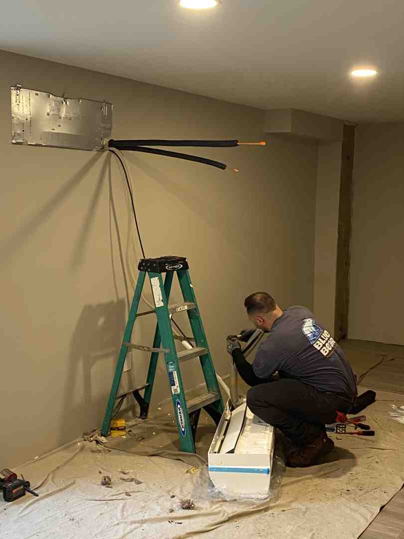 A sleek ductless indoor air handler mounted on a living room wall - central air vs mini split for the south shore homes A sleek ductless indoor air handler mounted on a living room wall - central air vs mini split for the south shore homes