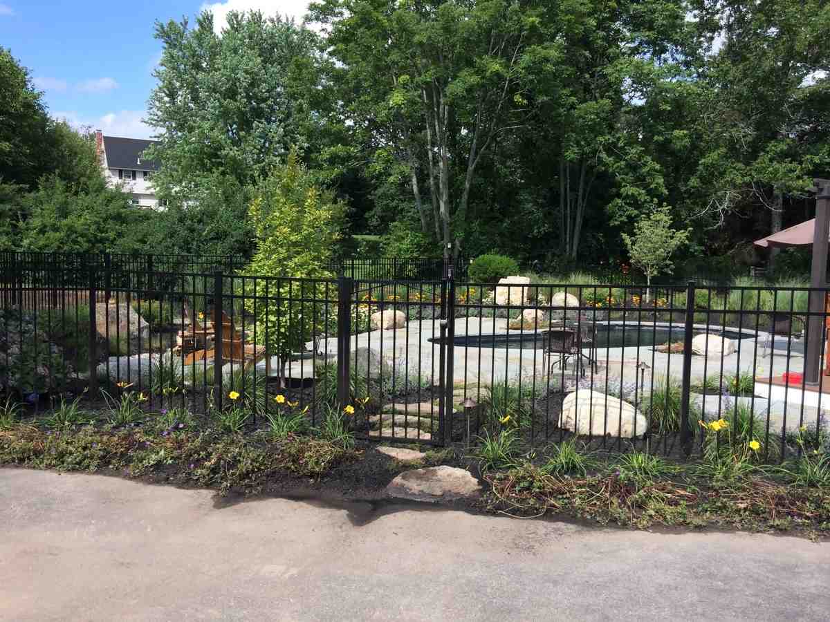 Lush plantings creating a natural border between patio hardscape and lawn area - Patio design Georgetown MA