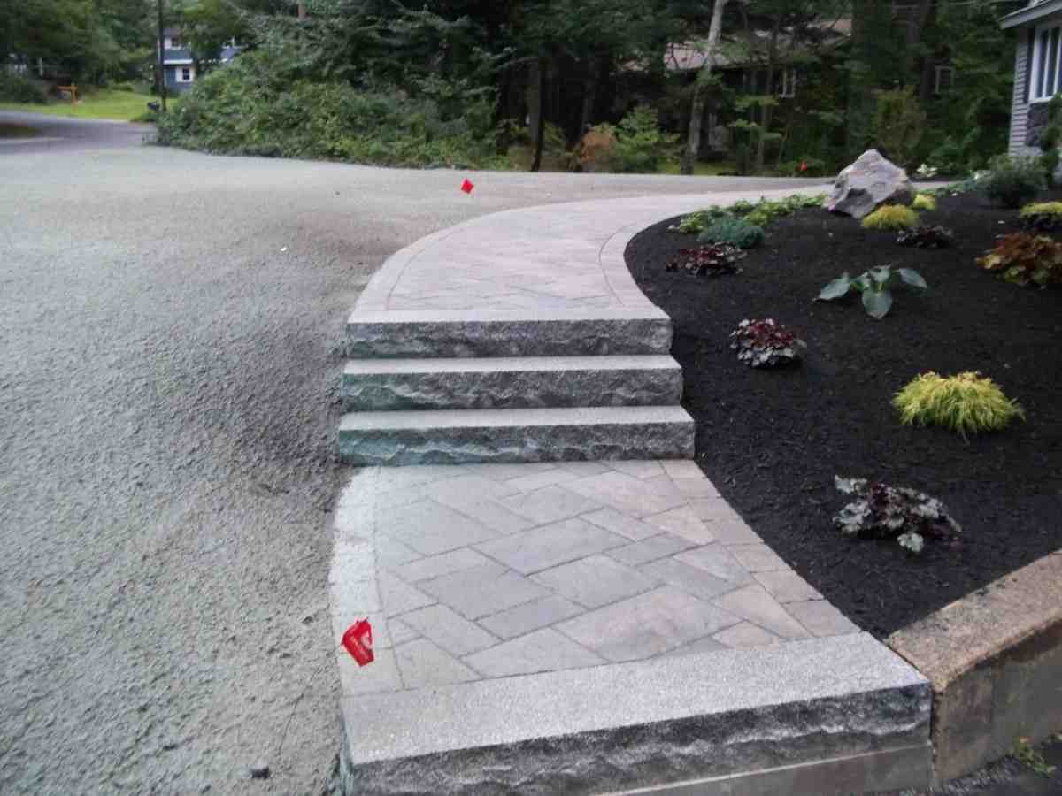 Various landscape materials including mulch, stone, and pavers stacked at a supply yard - landscape supply methuen ma