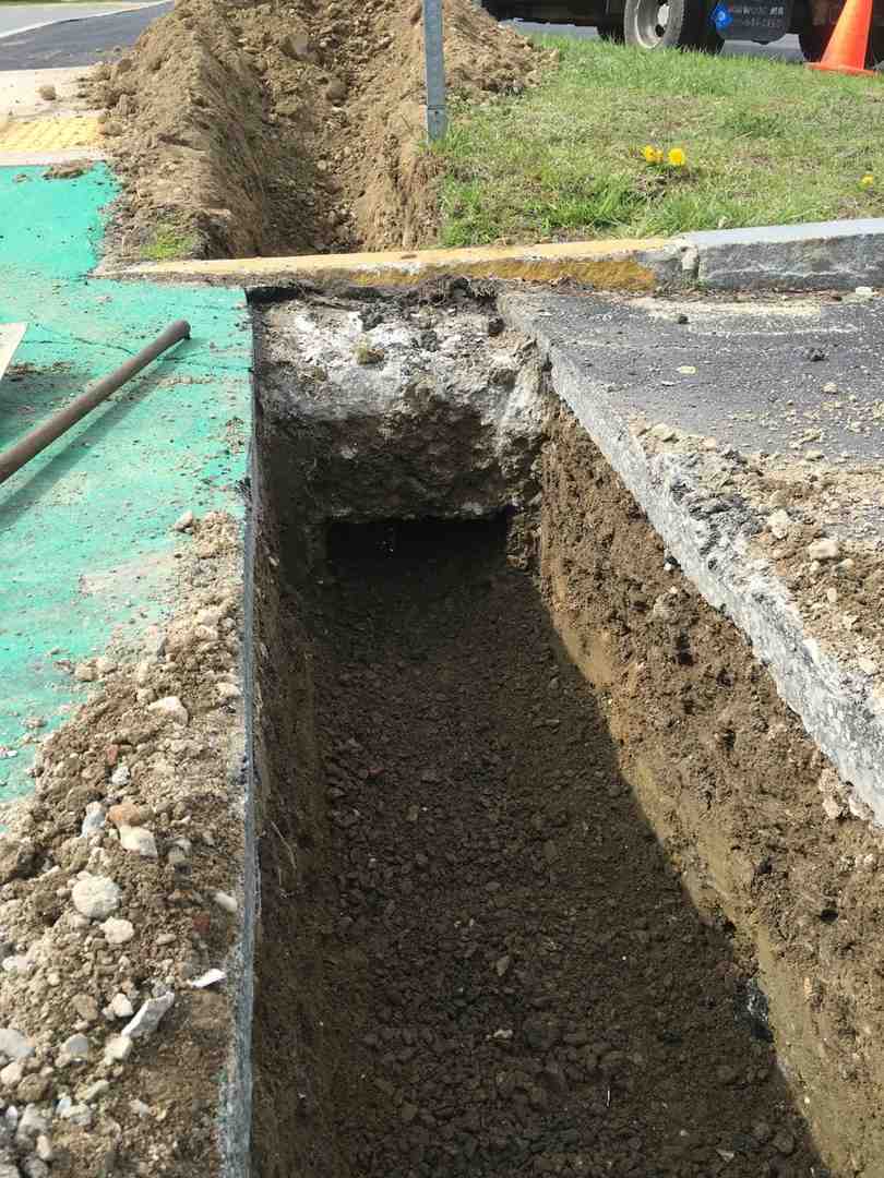 clearly marked and partially excavated trench for a brick walkway - making a walkway with bricks