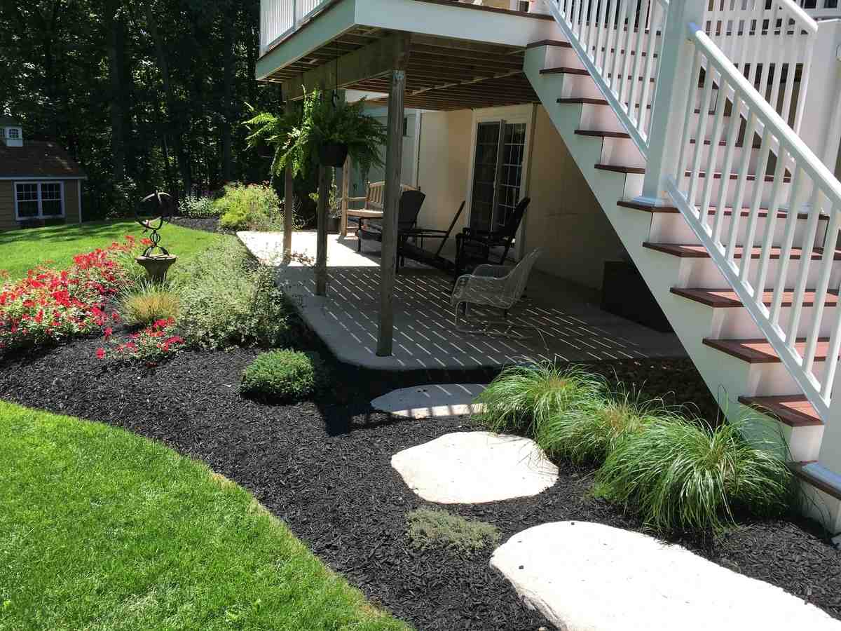 comparison of liftd wooden deck and ground-level stone patio - patio installation near me