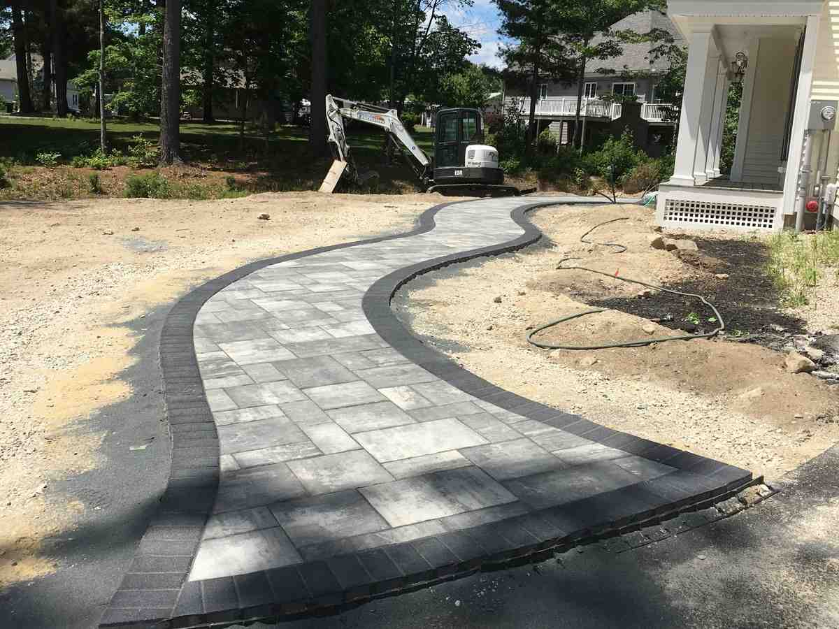 curved paver walkway integrated into a garden - paver walkway contractors