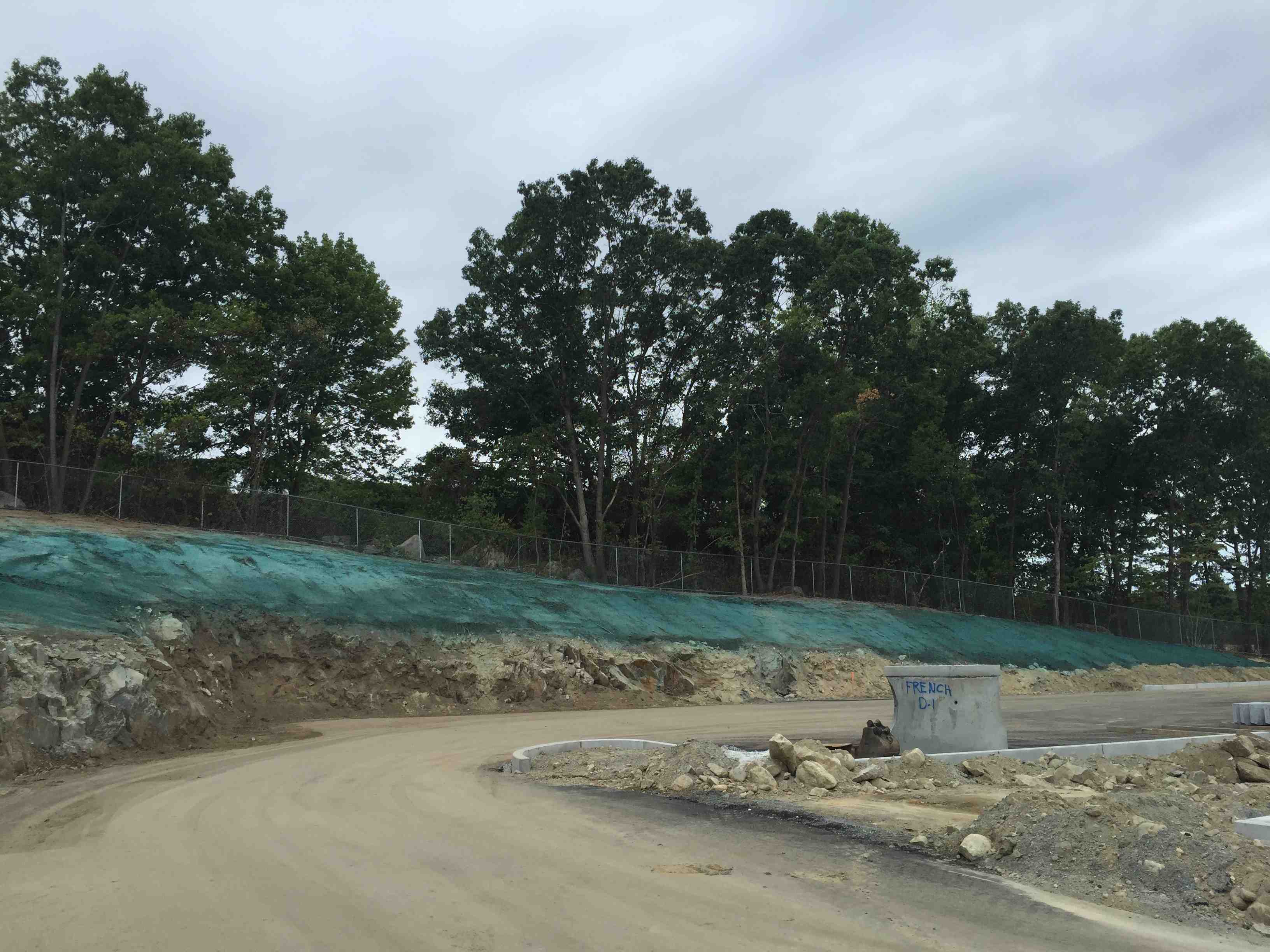 Base preparation and excavation process for commercial artificial grass showing grading and aggregate compaction