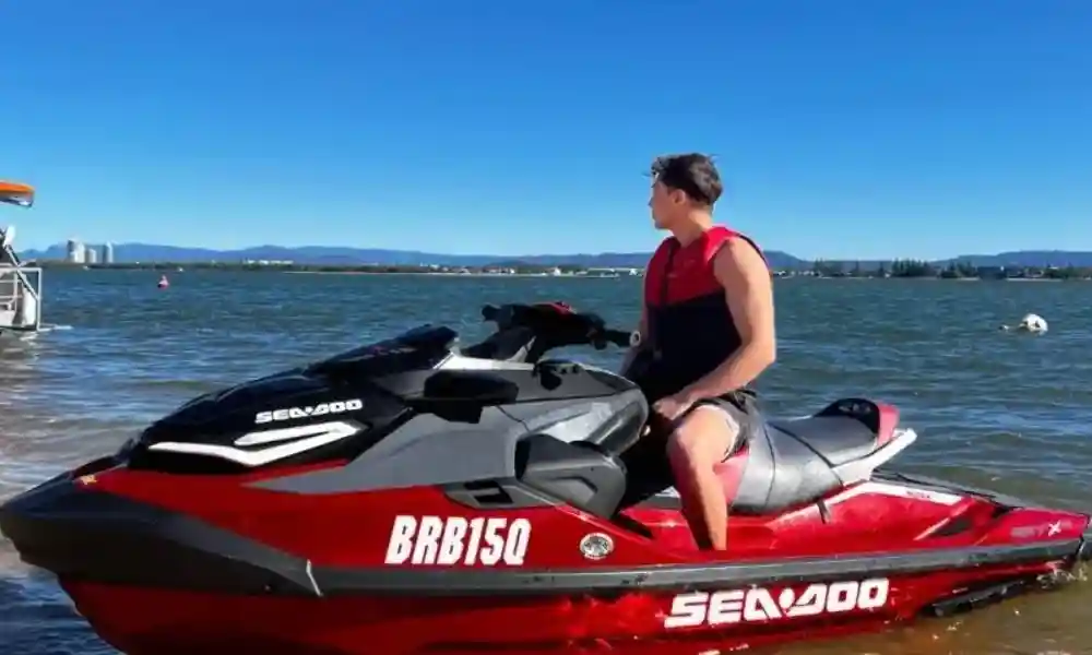Rider on the shore, correctly using a life vest and practising important jet ski safety tips before cruising the water. Rider on the shore, correctly using a life vest and practising important jet ski safety tips before cruising the water.