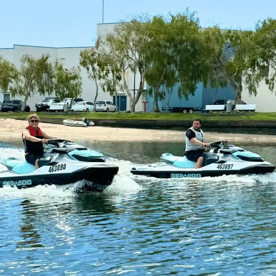 Two jet ski riders wearing life vests and keeping a safe distance, following proper jet ski safety tips. Two jet ski riders wearing life vests and keeping a safe distance, following proper jet ski safety tips.